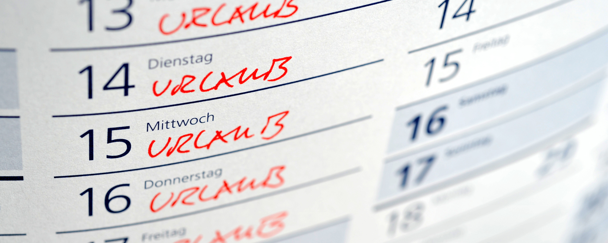 Stehkalender mit Tagen, an denen Urlaub handschriftlich in Rot eingetragen wurde