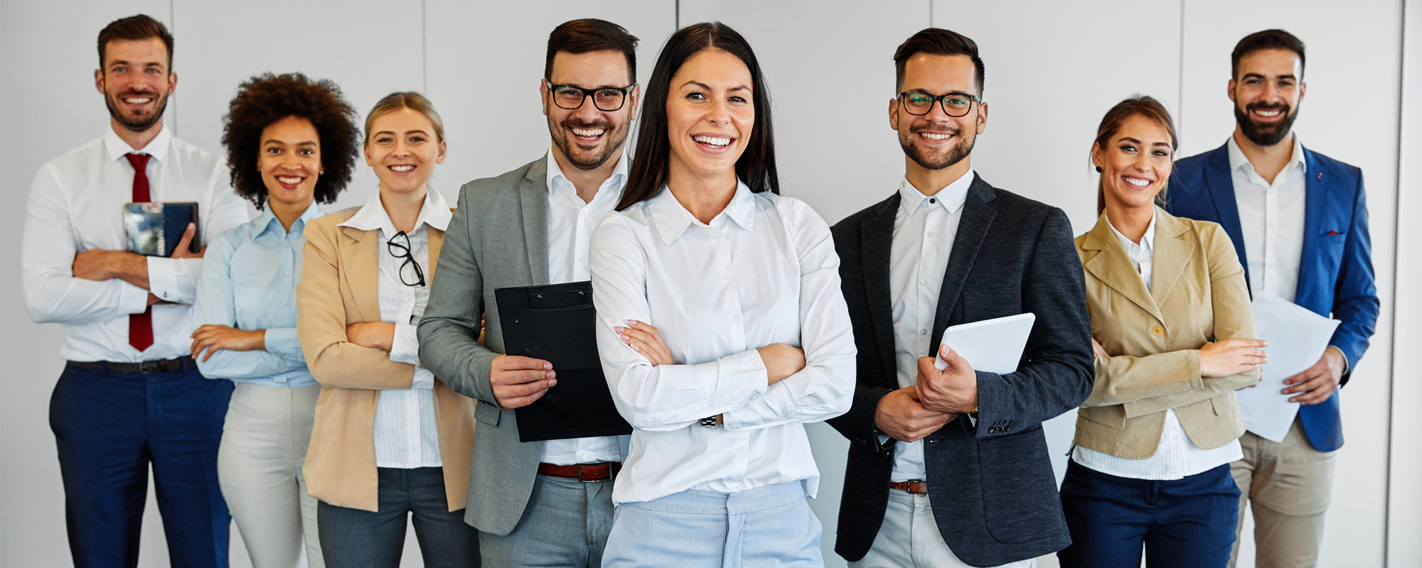 Ein Team steht um einen Tisch versammelt und legt die ausgestreckten Hände übereinander.